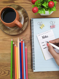 High angle view of hand holding book on table