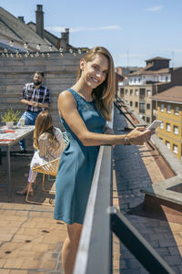Full length of happy woman standing against city in background