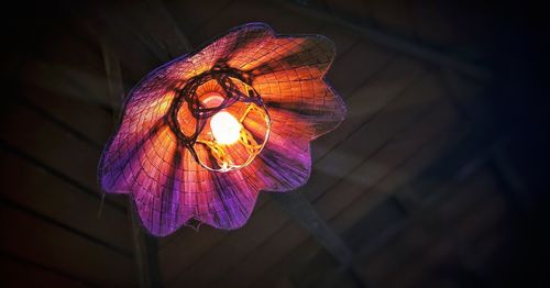 Low angle view of illuminated pendant lights hanging from ceiling