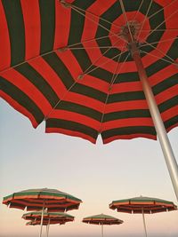 Low angle view of umbrellas on beach against sky