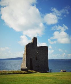 Built structure by sea against sky