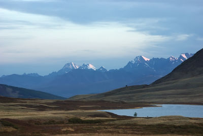 Scenic view of mountains against cloudy sky