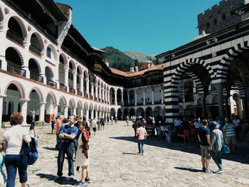 Group of people in historic building against sky