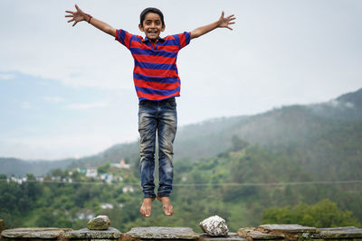 Little indian kid jumping with joy on the roof