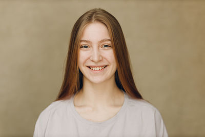 Portrait of young woman against wall