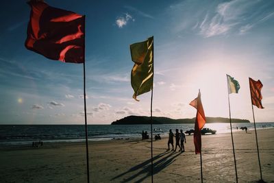 Scenic view of flags at beach against sky