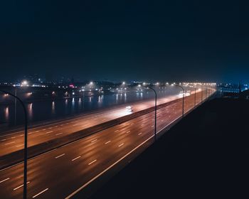 Light trails on road against sky at night