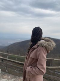 Rear view of woman standing on snow covered landscape