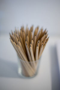 Close-up of pencils in glass on table