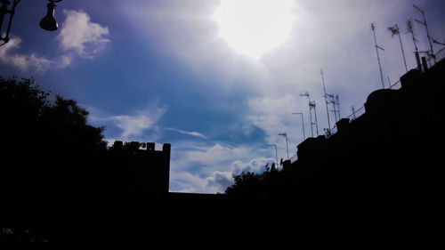 Low angle view of silhouette trees against sky