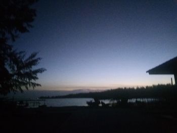 Scenic view of lake against clear sky at sunset