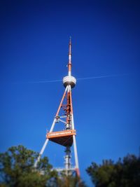 Low angle view of communications tower against clear blue sky