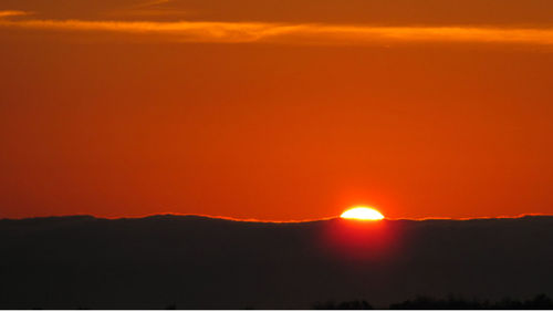 Scenic view of silhouette mountain against orange sky