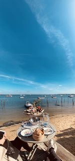 Panoramic view of people on beach against sky