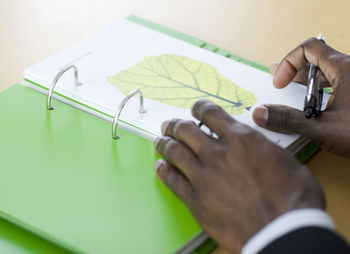 Close up of man''s hands on green notebook