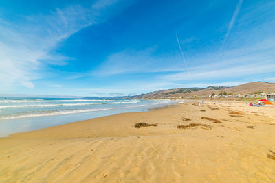 Scenic view of beach against blue sky