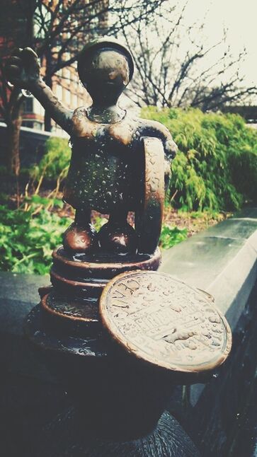 close-up, metal, art and craft, tree, sculpture, plant, day, art, no people, old, outdoors, animal representation, metallic, statue, creativity, human representation, focus on foreground, sunlight, growth, park - man made space