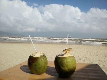 Close-up of coconuts drinks against beach