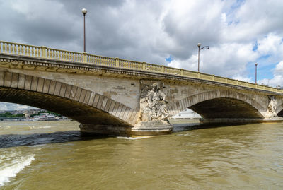 Arch bridge over river against sky