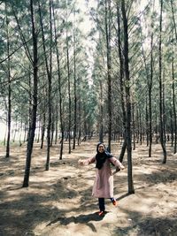 Full length of girl standing in forest