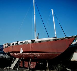 Low angle view of sailboat against blue sky