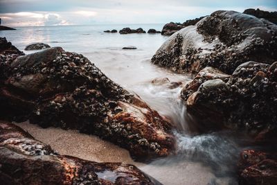 Scenic view of rocks in sea against sky