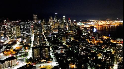 Illuminated cityscape against sky at night