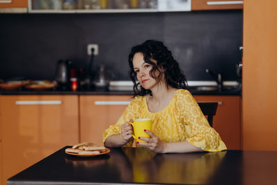 Portrait of young woman sitting on table