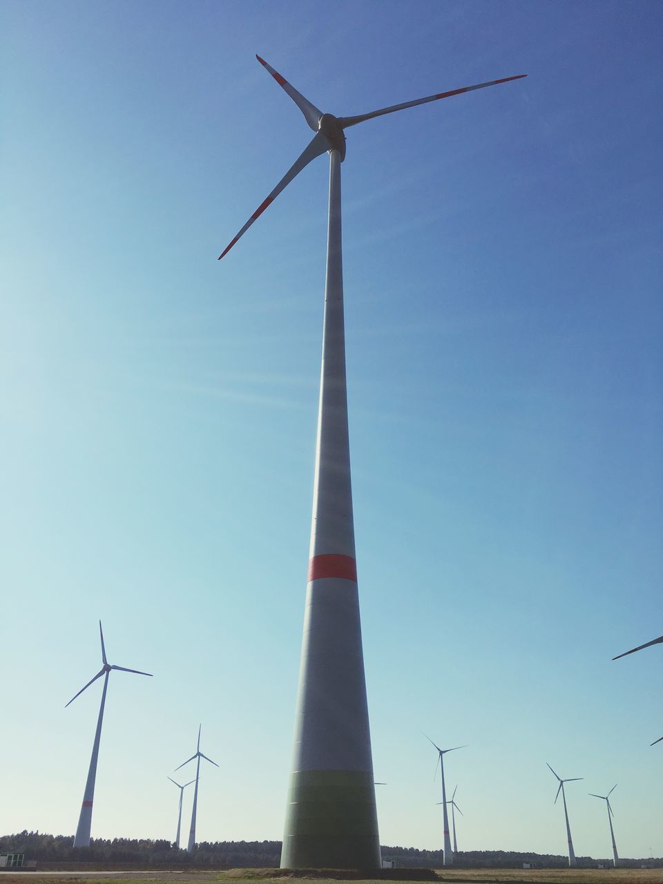 alternative energy, wind turbine, fuel and power generation, wind power, renewable energy, windmill, environmental conservation, low angle view, traditional windmill, technology, clear sky, sky, rural scene, blue, no people, built structure, day, crane - construction machinery, development, outdoors