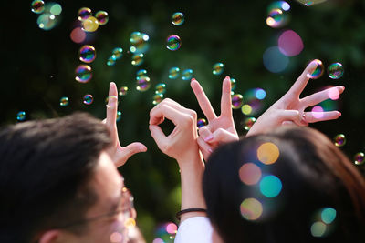 Hands spelling the word love at wedding