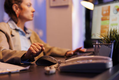 Midsection of businesswoman using laptop at office