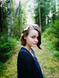 Portrait of smiling young woman in forest