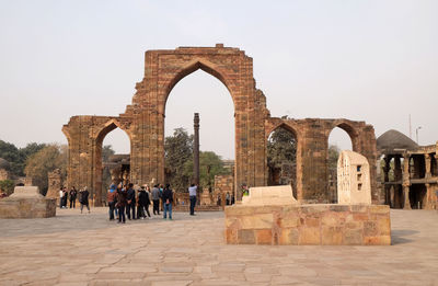 People at old ruins against clear sky