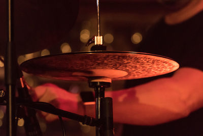 Midsection of drummer by cymbal during music concert