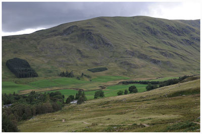 Scenic view of field and mountains against sky