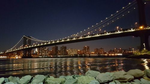 Suspension bridge over river at night