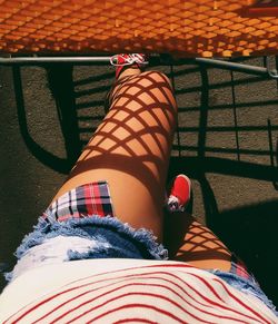 Low section of woman with shadow pattern on leg