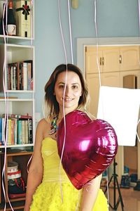 Happy girl with elegant yellow dress and balloons celebrating her bday