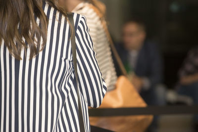 Rear view of woman wearing striped clothing outdoors