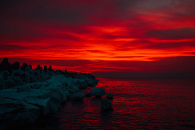 Scenic view of sea against orange sky