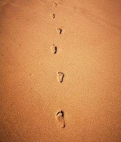 High angle view of footprints on sand at beach