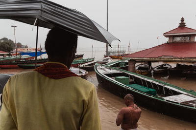 Rear view of people standing on boat in sea