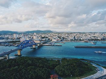 High angle view of cityscape by river against sky