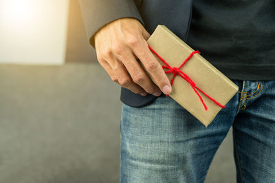 Midsection of man holding box