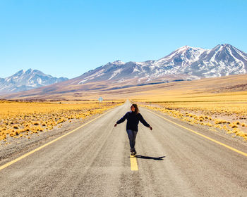 Rear view of man walking on road