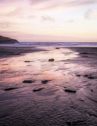 Scenic view of beach against sky during sunset