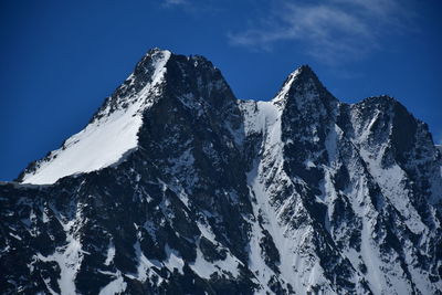 Scenic view of snowcapped mountains against blue sky
