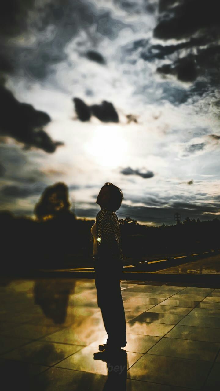 one person, sky, real people, cloud - sky, standing, full length, sunset, nature, lifestyles, silhouette, leisure activity, women, clothing, beauty in nature, adult, rear view, water, outdoors, looking at view