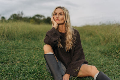 Portrait of young woman sitting on field