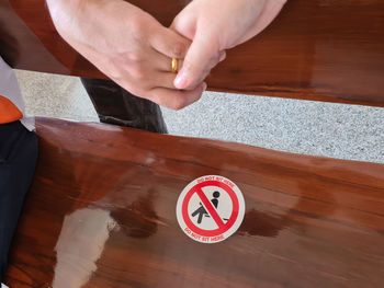 High angle view of hand holding cigarette on table